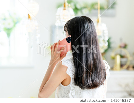 The back view of a woman talking on the phone 141046387