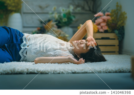 A tired woman lying on the floor 141046398