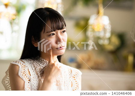 一位年輕的日本女子用手指輕撫下巴。 141046406