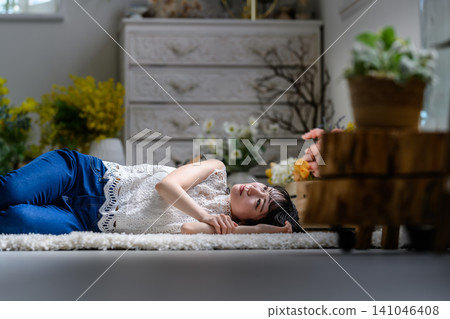 A woman lying on the floor, lost in thought. A woman lying on the floor, lost in thought. 141046408