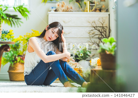 A young woman sitting inside A young woman sitting inside 141046427