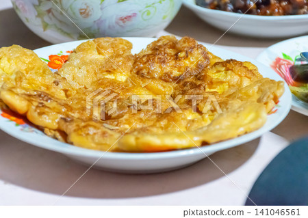 Golden Thai style fried omelette served plate crispy edges fluffy texture home cooked comfort food delicious traditional meal Golden Thai style fried omelette served plate crispy edges fluffy texture home cooked comfort food delicious traditional meal 141046561