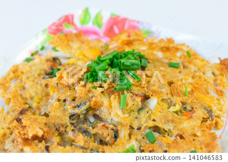 Crispy oyster omelet topped fresh spring onion served plate featuring golden texture savory flavors ideal for street food restaurant Asian cuisine themes Crispy oyster omelet topped fresh spring onion served plate featuring golden texture savory flavors ideal for street food restaurant Asian cuisine themes 141046583
