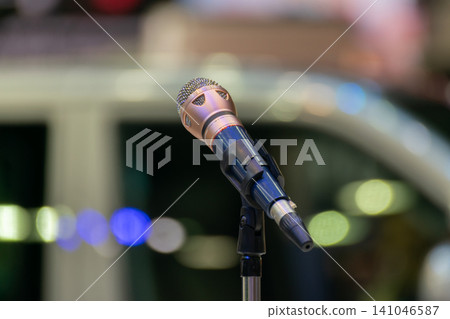Closeup of stage microphone stand colorful bokeh lights the background ideal for music performance public speaking events entertainment themes Closeup of stage microphone stand colorful bokeh lights the background ideal for music performance public speaking events entertainment themes 141046587