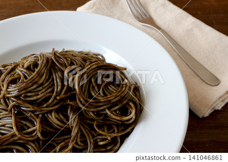 Squid ink pasta as a table background Squid ink pasta as a table background 141046861