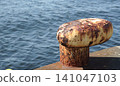 A rusty mooring post standing on the quay 141047103