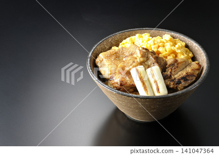 一碗炒蛋、烤青蔥和炭烤雞肉,以黑色為背景拍攝。 一碗炒蛋、烤青蔥和炭烤雞肉,以黑色為背景拍攝。 141047364