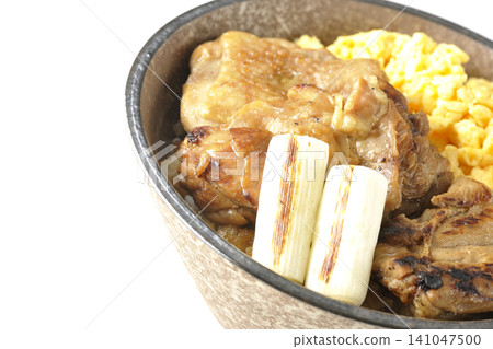 A bowl of scrambled eggs, grilled green onions, and charcoal-grilled chicken photographed against a white background. A bowl of scrambled eggs, grilled green onions, and charcoal-grilled chicken photographed against a white background. 141047500