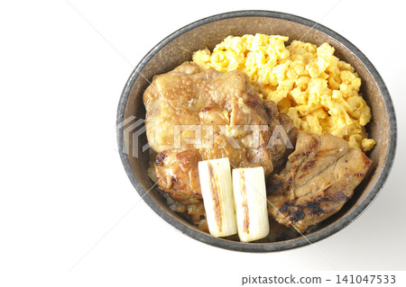 A bowl of scrambled eggs, grilled green onions, and charcoal-grilled chicken photographed against a white background. A bowl of scrambled eggs, grilled green onions, and charcoal-grilled chicken photographed against a white background. 141047533