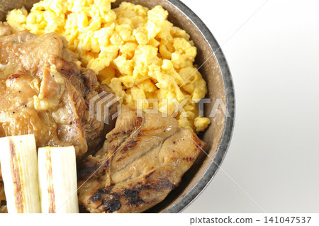 A bowl of scrambled eggs, grilled green onions, and charcoal-grilled chicken photographed against a white background. A bowl of scrambled eggs, grilled green onions, and charcoal-grilled chicken photographed against a white background. 141047537