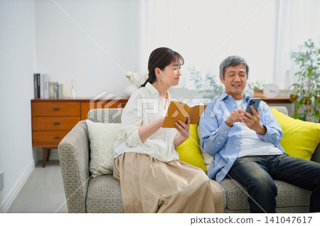一對老年夫婦在沙發上放鬆休息。 141047617