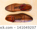 Pair of new brown leather men's dress shoes neatly arranged on a clean surface 141049207