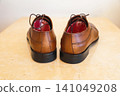Pair of new brown leather men's dress shoes neatly arranged on a clean surface 141049208