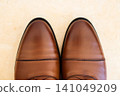 Pair of new brown leather men's dress shoes neatly arranged on a clean surface 141049209