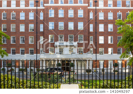 Traditional red brick residential apartment building facade in London with iron fence Traditional red brick residential apartment building facade in London with iron fence 141049297