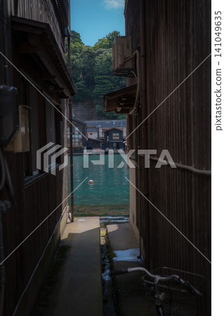The boathouses of Ine and the emerald green sea can be glimpsed through the gaps between historic houses. The boathouses of Ine and the emerald green sea can be glimpsed through the gaps between historic houses. 141049635