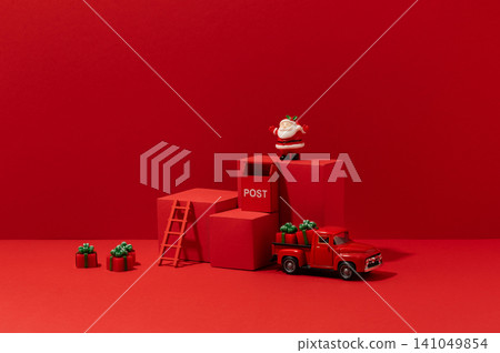Bright Christmas product display scene with vintage toy truck, podium props, and holiday decorations against a bold monochromatic red studio background. Bright Christmas product display scene with vintage toy truck, podium props, and holiday decorations against a bold monochromatic red studio background. 141049854