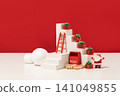 Festive Christmas mockup scene with white stepped display podiums, holiday figurines, and decorative props against a high-contrast red studio background, suitable for seasonal product advertising. 141049855