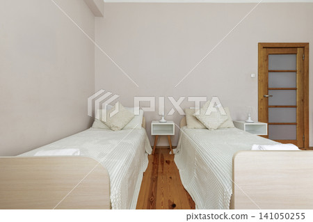 Twin Bedroom Interior with Separate Beds and Wooden Door Twin Bedroom Interior with Separate Beds and Wooden Door 141050255