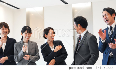 一群商務人士在辦公室大廳裡笑 一群商務人士在辦公室大廳裡笑 141050888