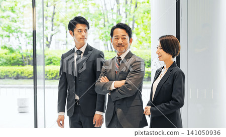 一群行政商務人士在大廳交談 一群行政商務人士在大廳交談 141050936