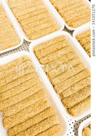 Delicious crunchy snacks prepared and arranged on trays at a food production facility Delicious crunchy snacks prepared and arranged on trays at a food production facility 141051270