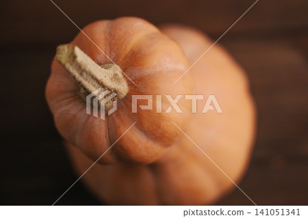 Pumpkins placed on a wooden surface during the autumn season in a cozy setting 141051341