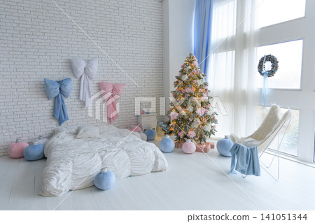 Cozy winter scene with a decorated Christmas tree and soft pastel decor in a bright room 141051344