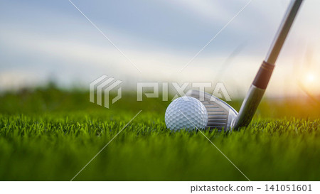 Golf clubs and balls on a green lawn in a beautiful golf course with morning sunshine. Golf clubs and balls on a green lawn in a beautiful golf course with morning sunshine. 141051601