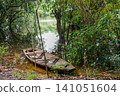 small wooden canoe on riverbank in the middle of Brazilian Amazon rainforest 141051604
