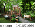 Beautiful greenhouse surrounded by lush greenery in a peaceful garden setting 141051669