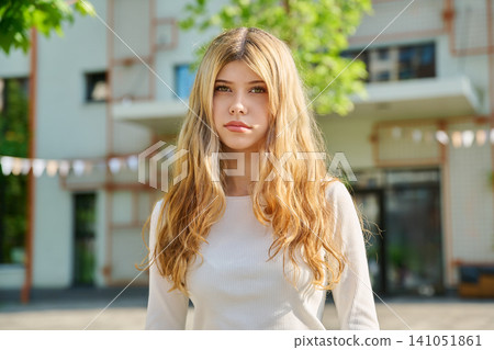 Teenage blonde student girl looking at camera Teenage blonde student girl looking at camera 141051861