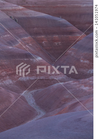 Vast layered badlands in Utah display serene blend of purple, blue, and reddish brown hues at twilight. Geological formation creates an awe inspiring, ancient landscape Vast layered badlands in Utah display serene blend of purple, blue, and reddish brown hues at twilight. Geological formation creates an awe inspiring, ancient landscape 141051974