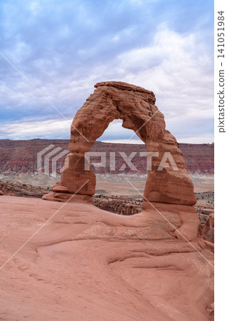 Majestic natural arch, stunning sandstone formation, stands proudly in rugged utah desert landscape under dramatic sky. impressive sight inspires wonder and profound sense of awe 141051984