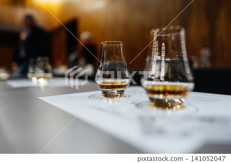 Tasting fine spirits at an evening whiskey exploration event Tasting fine spirits at an evening whiskey exploration event 141052047
