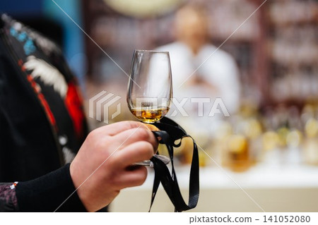 Savoring the rich aroma of whiskey in a bustling distillery event Savoring the rich aroma of whiskey in a bustling distillery event 141052080