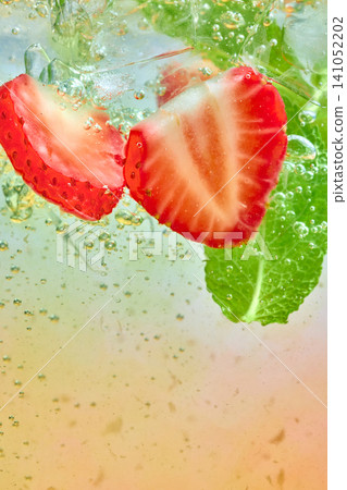 Strawberry mint sparkling drink with ice bubbles and fruit slices macro. 141052202