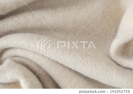 Cashmere beige fabric, top view. Draped, texture, background. Natural wool clothing Cashmere beige fabric, top view. Draped, texture, background. Natural wool clothing 141052759