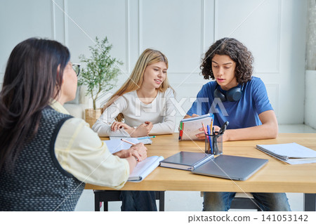 Social worker or teacher listening to teenage students Social worker or teacher listening to teenage students 141053142