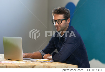 Smile, creative and man at laptop thinking for ideas, online research and reading email in office with glasses. Brainstorming, computer and designer at desk with business plan in professional career 141053341