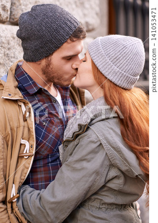Couple, love and kiss with closeup in outdoor in against wall on cold weather, together and support in London. Affection, relationship and bonding for romance with soulmate, care and happiness Couple, love and kiss with closeup in outdoor in against wall on cold weather, together and support in London. Affection, relationship and bonding for romance with soulmate, care and happiness 141053471