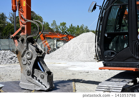 A demolition site using heavy machinery under a blue sky A demolition site using heavy machinery under a blue sky 141053798