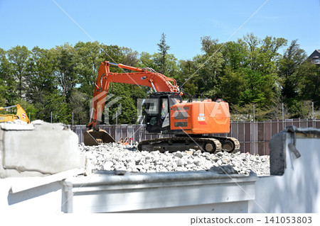 A demolition site using heavy machinery under a blue sky A demolition site using heavy machinery under a blue sky 141053803