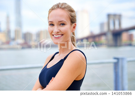 Exercise, portrait and woman with arms crossed for fitness, morning workout or running competition in city. Smile, wellness and face of female person for cardio, energy and confidence in New York 141053866