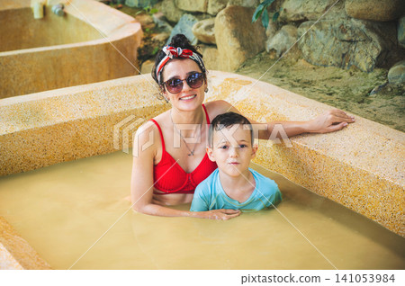 happy family is relaxing in mud bath at a spa complex. Mom and son on vacation at a health resort in Vietnam 141053984