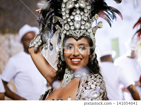 Portrait, happy woman and dancer at carnival with band for performance, party or celebration. Face, samba and Brazilian person at music festival in feather costume, makeup and smile at concert event 141054041