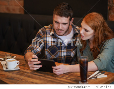 Couple, browsing and checking menu with tablet for dinner date, streaming or review at indoor restaurant. Young man and woman chilling or relax with technology for social media at cafe or coffee shop Couple, browsing and checking menu with tablet for dinner date, streaming or review at indoor restaurant. Young man and woman chilling or relax with technology for social media at cafe or coffee shop 141054167