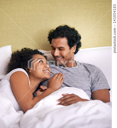 Bed, woman and man relax with smile, cuddle and rest on soft mattress, love and romance for couple. Partners, male person and girl in bedroom, happy and together in pyjamas, break and weekend 141054183