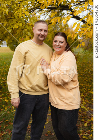 happy standing together in autumn park with fallen leaves, front view, yellow and green foliage, casual sweatshirts and jeans, family story theme, commercial natural light, copy. happy standing together in autumn park with fallen leaves, front view, yellow and green foliage, casual sweatshirts and jeans, family story theme, commercial natural light, copy. 141054230