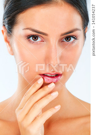 Woman, face and hand on lips for beauty, dermatology and wellness with shine isolated on white background. Skincare, portrait and balm on mouth for cosmetic care, manicure and healthy skin in studio Woman, face and hand on lips for beauty, dermatology and wellness with shine isolated on white background. Skincare, portrait and balm on mouth for cosmetic care, manicure and healthy skin in studio 141054237